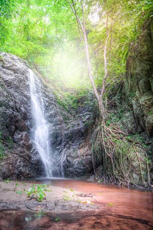 Beautiful waterfall on a mountain slope in deep forest. Tropical waterfall in rain forest.の写真素材