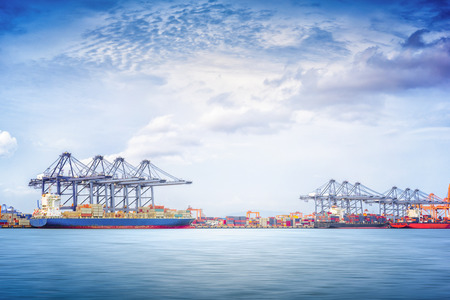 Container Cargo ship with working crane bridge in seaport for logistic import export background and transport industry.の写真素材