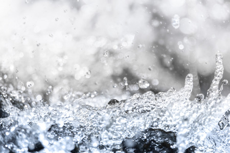 Close up splashed water and water bokeh on the large boulders, waves splashの写真素材