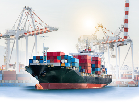 Logistics and transportation of International Container Cargo ship with ports crane bridge in harbor for logistic import export background and transport industry.の写真素材