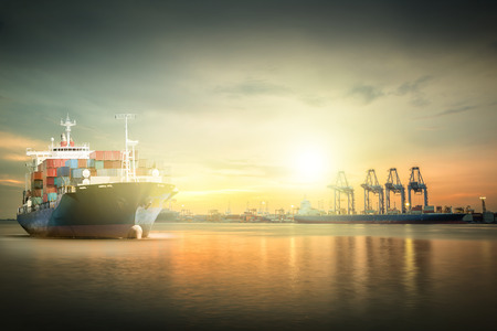 Logistics and transportation of International Container Cargo ship with ports crane bridge in harbor for logistic import export background and transport industry.の写真素材