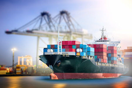 Logistics and transportation of International Container Cargo ship with ports crane bridge in harbor for logistic import export background and transport industry.の写真素材