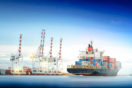 Logistics and transportation of International Container Cargo ship with ports crane bridge in harbor for logistic import export background and transport industry.の写真素材