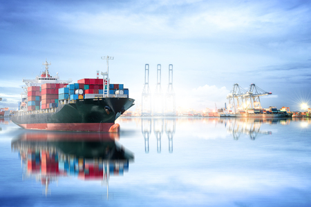 Logistics and transportation of International Container Cargo ship with ports crane bridge in harbor for logistic import export background and transport industry.の写真素材