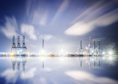 Logistics and transportation of working crane bridge in shipyard background with water reflectionsの写真素材
