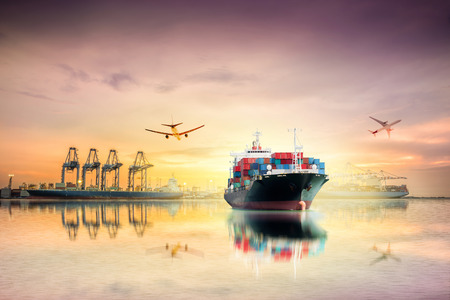 Logistics and transportation of International Container Cargo ship and Cargo plane with ports crane bridge in harbor at Twilight sky for logistic import export background and transport industry.の写真素材