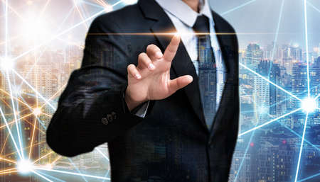 Double exposure of business man pointing space on city night background, internet of things and advertisement conceptの写真素材