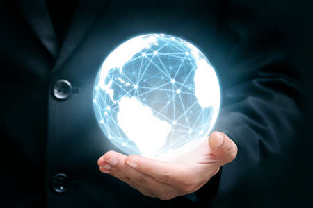 Businessman holding global network over the world for connections, global business technology conceptの写真素材