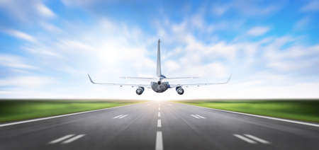 Airplane taking off from Airport runway at beautiful blue sky, Commercial plane and Travel concept, Aircraft with motion blurred Background, back viewの写真素材