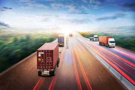 Truck Transport and Logistics Cargo Freight Import Export Concept, Truck with Red Container run on highway road at sunset sky at motion blur, Aerial view, Transportation industry backgroundの写真素材