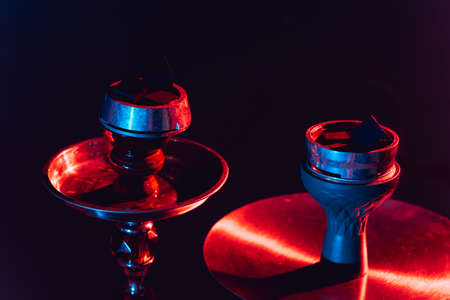 hookah bowl, shisha and coals close-up on a black background with colored lightingの写真素材