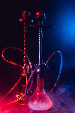 modern hookah, shisha on a smoky black background with neon lightingの写真素材