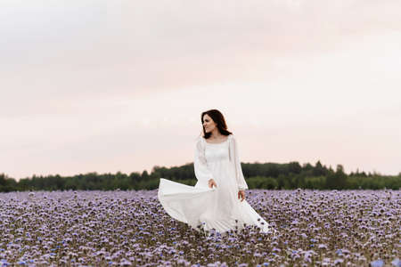 Provence blooming field. The girl is happy and laughs running through the blooming field.の写真素材