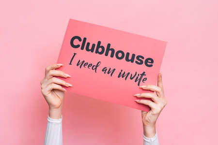 VICHUGA, RUSSIA, February 18, 2021: A womans hand holds a sign reading CLUBHOUSE I need an invite.