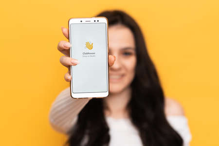VICHUGA, RUSSIA - February 18, 2021. The girl is holding a smartphone with the Club house app on the screen. Clubhouse Drop-in audio is a voice-activated social media app.のeditorial素材