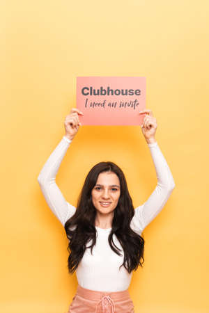 VICHUGA, RUSSIA, February 18, 2021: A young girl holds a sign that says CLUBHOUSE I need an invite.のeditorial素材