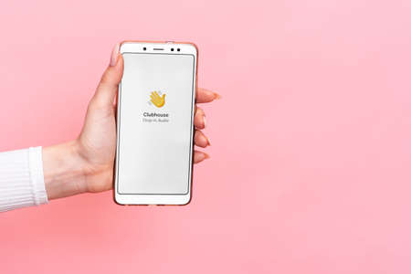 VICHUGA, RUSSIA - February 18, 2021. A hand holds a smartphone with the Club house app on the screen. Clubhouse Drop-in audio is a voice-activated social media app.のeditorial素材