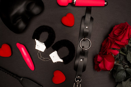 Set of adult toys on a dark background with red rosesの写真素材