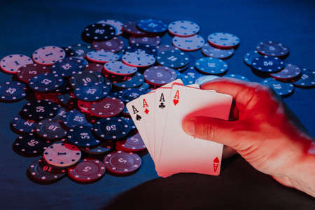 mens hands hold cards , a set of aces on the background of playing chipsの写真素材