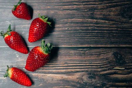 ripe strawberry berries on a dark wooden background. space for your textの写真素材