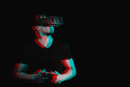 A young man in virtual reality glasses is playing video games. with space for text. Black and white with 3D glitch virtual reality effectの写真素材