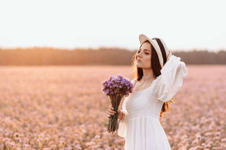 Beautiful brunette in a lavender field at sunset Amazing Portraitの写真素材
