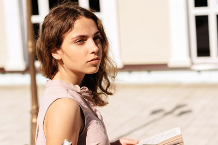 a young girl is relaxing in the Park and reading a bookの写真素材