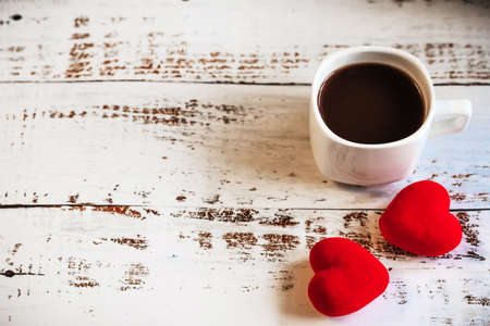 coffee Cup and red hearts on a white wooden background. Valentines day. Place for text, place for copying.の写真素材