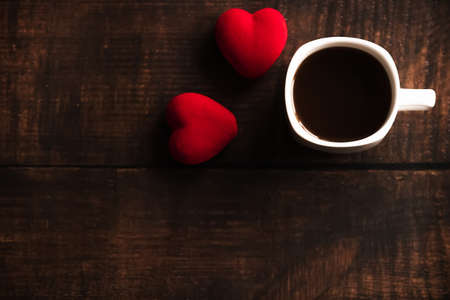 a Cup of coffee and red hearts on a dark wooden background. Valentines day. Place for text, place for copying.の写真素材