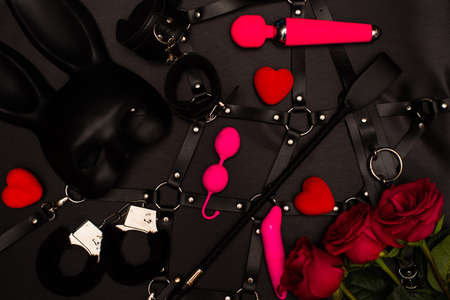 Set of adult toys on a dark background with red rosesの写真素材
