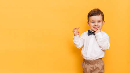 Happy child kid smiling boy on yellow background. Health care, dental hygiene. Mockup, copy spaceの写真素材