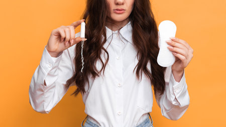 Studio shot of a young girl holding a Panty liner and tampons for menstruation.. The concept of feminine hygiene.の写真素材