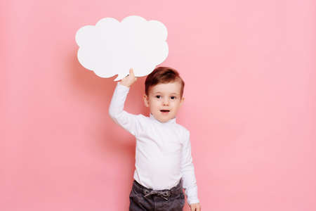 studio portrait of a boy with a blank white board in the shape of a cloudの写真素材