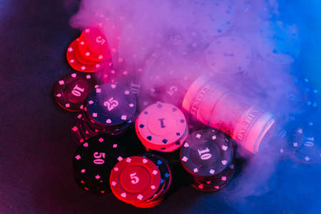 poker. playing chips, money placed on a bet. close up. with puffed smoke in the photoの写真素材