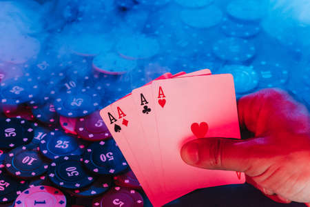 mens hands hold cards against the background of playing chips. there is smoke in the photoの写真素材