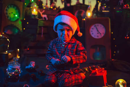 Christmas decorations. A frustrated boy is sitting on the floor.の写真素材
