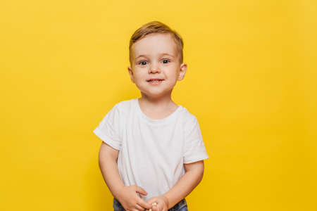 Smiling little boy on a yellow background. Copy space.の写真素材