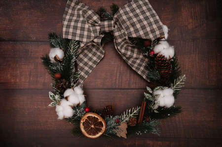 Christmas wreath of Christmas decorations, cones, spices on a wooden background. In the style of flatley. The concept of celebrating the New Year. Top view.の写真素材