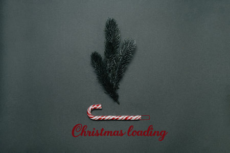Christmas flatley. Christmas loading inscription under fir twigs and caramel cane.の写真素材