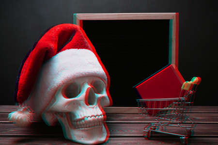 Glitch effect. A letter board with a skull in a Santa Claus hat, a mini grocery cart and a red box in it. Design to promote the winter sale at the end of the year. place for textの写真素材
