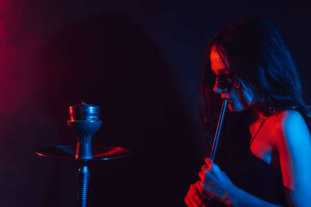 Hookah atmosphere. The girl enjoys smoking a hookah, sheesha. Place for your textの写真素材