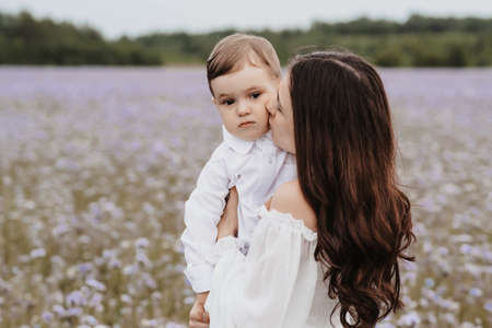 mother and son on the background of a blooming purple fieldの写真素材