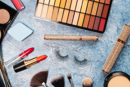 set of decorative cosmetics, makeup brushes on a blue background. the view from the topの写真素材