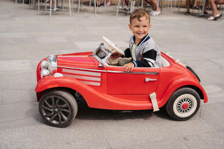 A little boy poses in a mini racing car. Play and relax in the fresh air.の写真素材