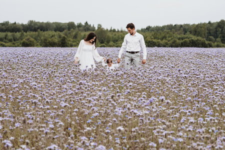 Beautiful young family with a boy resting in a field of flowers.の写真素材