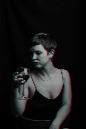 beautiful young girl tries and evaluates red wine. Black and white with glitch effectの写真素材