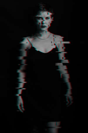 portrait of a beautiful girl standing on a dark background. noise is superimposed on the photo. Black and white with glitch effectの写真素材