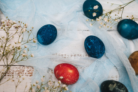 Easter eggs, small white flowers and decorations on a light background. Happy easter flat lay...