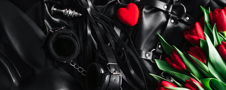 on Valentines day, a set of adult toys on a black silk background. red Tulip. Horizontal wide photo subtitle, cover. copy-spaceの写真素材