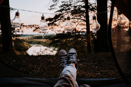 A close-up photo of the intentions of womens legs. The concept of a tourist trekking expedition. View from the tent to the landscapeの写真素材
